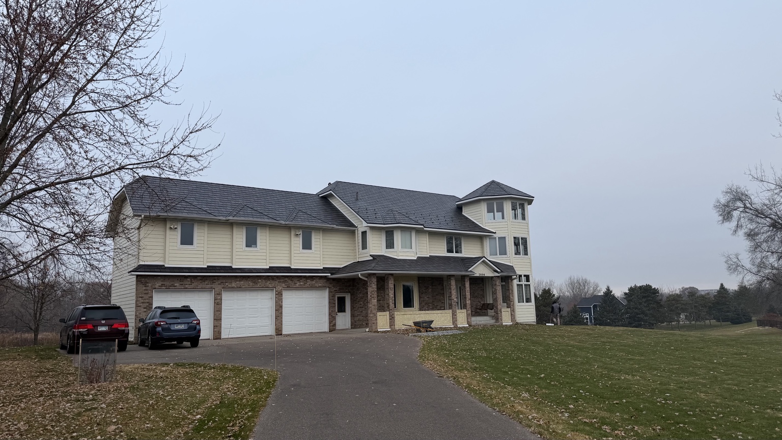 Two-story home with dark roof and light exterior